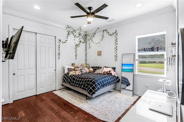 bedroom with ornamental molding, a closet, ceiling fan, and dark hardwood / wood-style floors