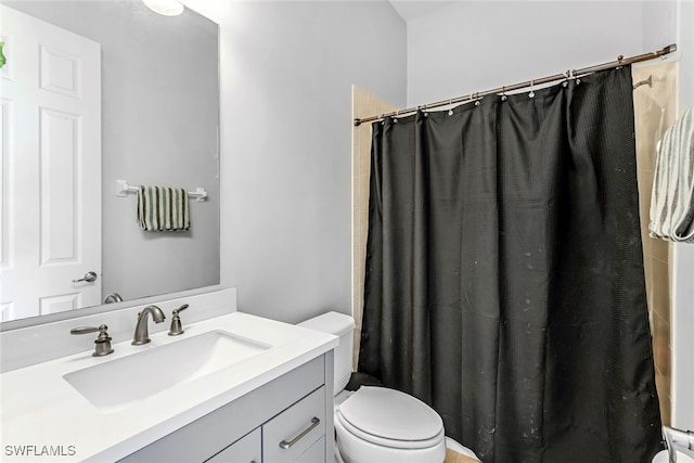 bathroom with walk in shower, toilet, and vanity