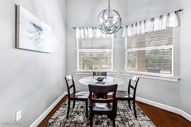 dining space with hardwood / wood-style flooring and a notable chandelier