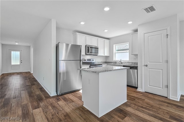 kitchen with dark hardwood / wood-style floors, white cabinetry, a center island, and stainless steel appliances