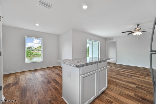 kitchen with ceiling fan, a center island, dark hardwood / wood-style floors, and a healthy amount of sunlight