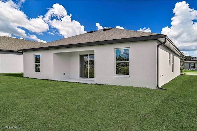 rear view of house featuring a yard