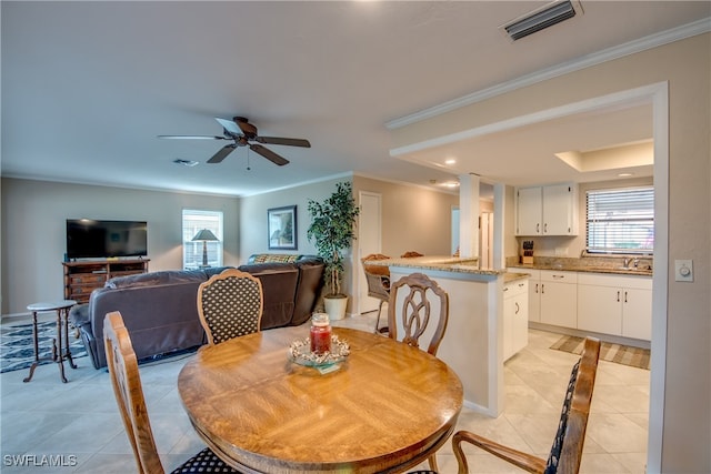 dining room featuring ornamental molding, ceiling fan, and light tile patterned floors