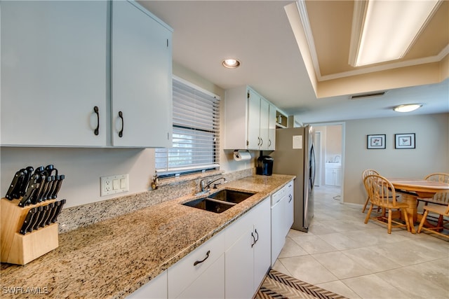 kitchen with white cabinets, white dishwasher, light stone countertops, and sink