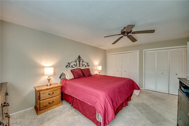 tiled bedroom with ceiling fan and multiple closets