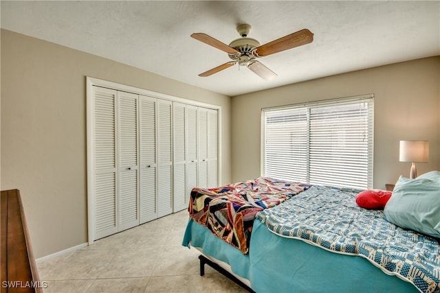 tiled bedroom featuring ceiling fan and a closet