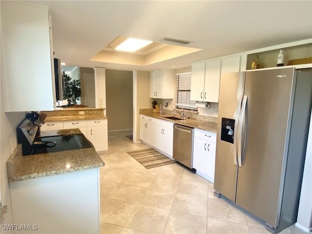 kitchen with white cabinets, a raised ceiling, appliances with stainless steel finishes, and sink