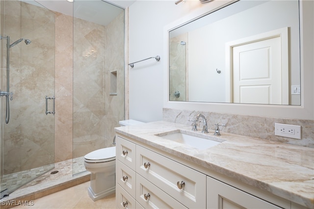 bathroom featuring toilet, vanity, tile patterned flooring, and a shower with door