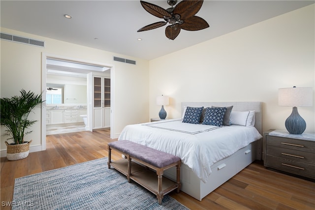 bedroom with ceiling fan, wood-type flooring, and connected bathroom