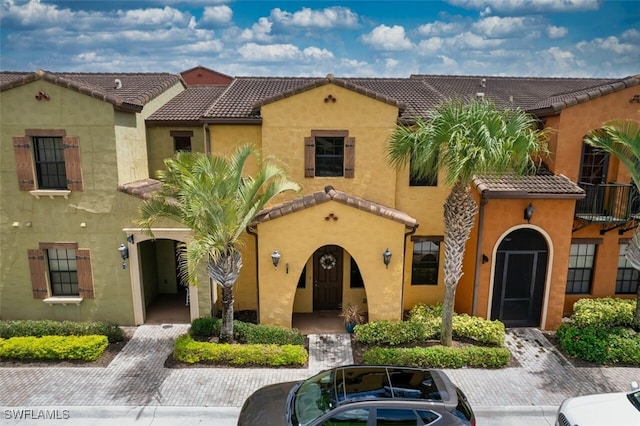 mediterranean / spanish home with a tile roof and stucco siding