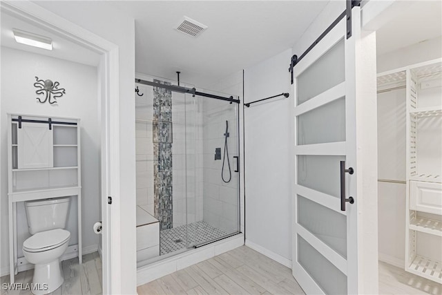 bathroom featuring wood-type flooring, a shower with shower door, and toilet