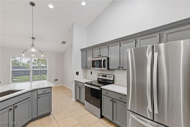 kitchen with gray cabinets, hanging light fixtures, and appliances with stainless steel finishes