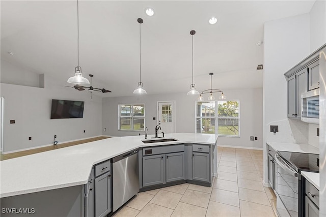 kitchen with decorative light fixtures, sink, appliances with stainless steel finishes, and vaulted ceiling