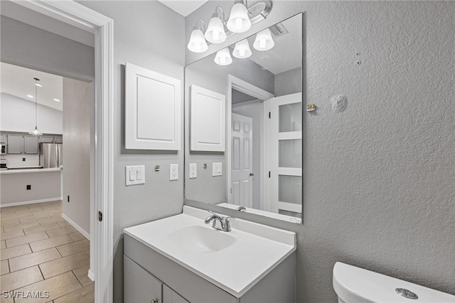 bathroom featuring tile patterned floors, vanity, lofted ceiling, and toilet