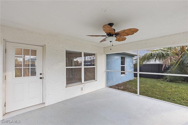 unfurnished sunroom with ceiling fan