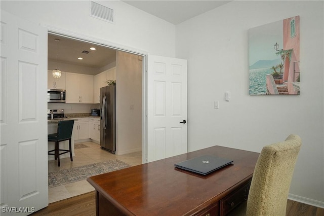 office featuring light wood-type flooring, baseboards, visible vents, and recessed lighting