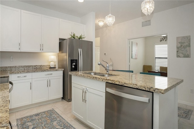 kitchen featuring an inviting chandelier, pendant lighting, a kitchen island with sink, stainless steel appliances, and white cabinets