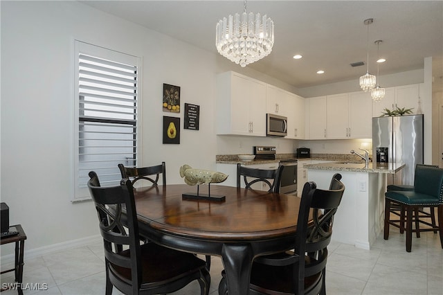 dining space featuring light tile patterned floors, sink, and a notable chandelier