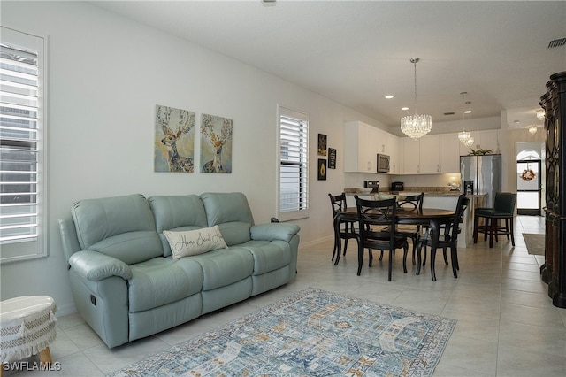 tiled living room featuring an inviting chandelier