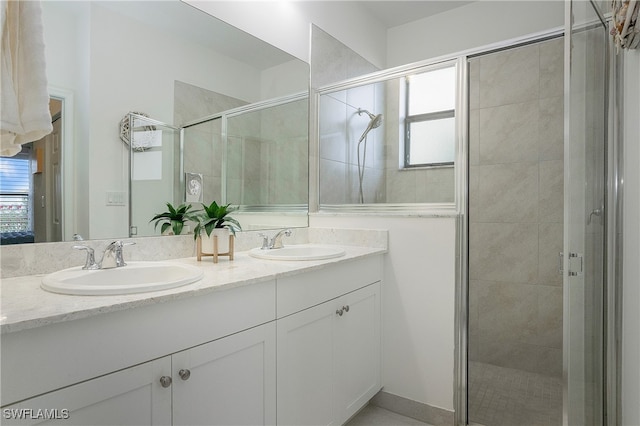 bathroom featuring a shower with door and vanity