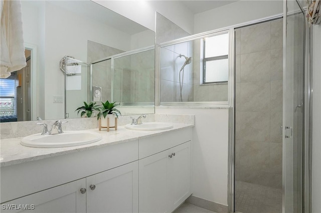 full bathroom with double vanity, a stall shower, and a sink