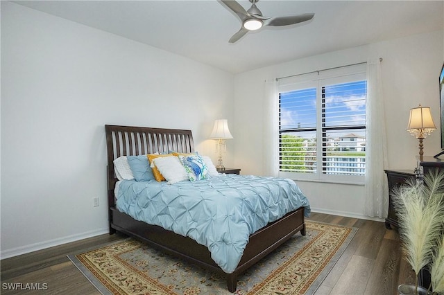 bedroom with baseboards, wood finished floors, and ceiling fan