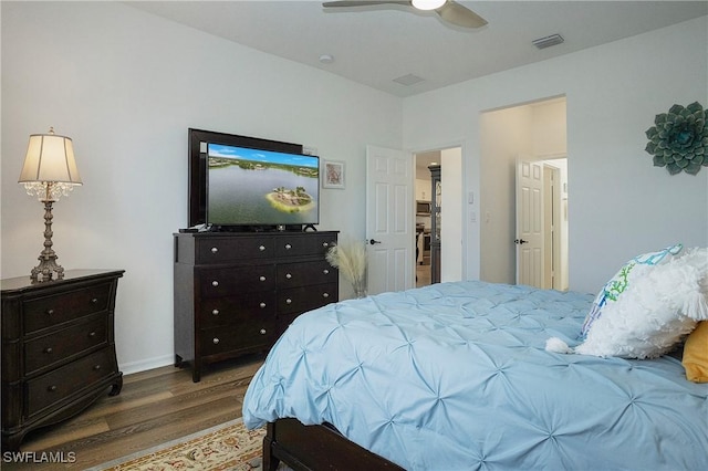 bedroom featuring wood finished floors, visible vents, a ceiling fan, and baseboards