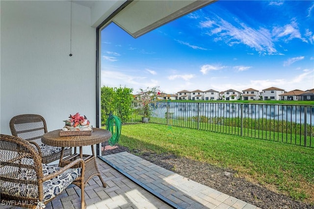 view of patio / terrace featuring a fenced backyard, a water view, and a residential view