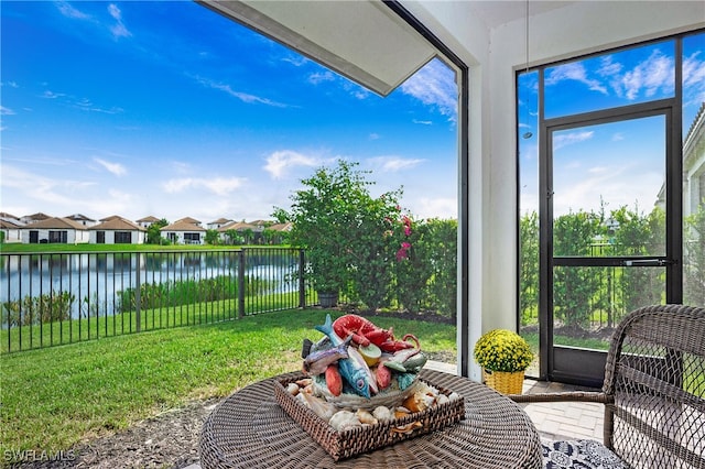 sunroom featuring a water view