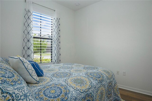 bedroom with baseboards and wood finished floors