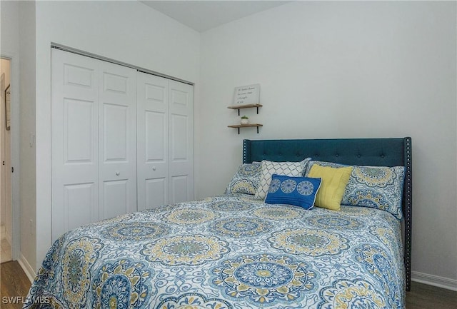 bedroom featuring baseboards, wood finished floors, and a closet