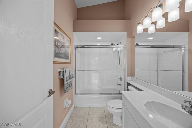 full bathroom with shower / bath combination with glass door, vanity, vaulted ceiling, tile patterned flooring, and toilet