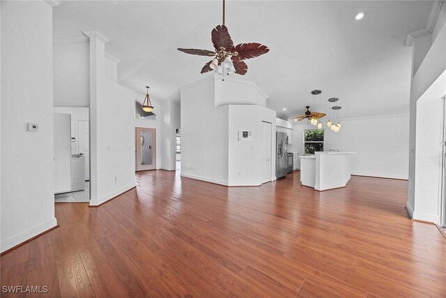 unfurnished living room with ceiling fan, ornamental molding, and hardwood / wood-style flooring