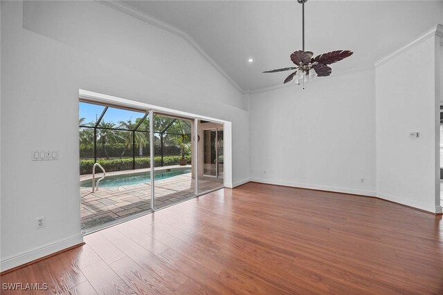 spare room featuring crown molding, high vaulted ceiling, hardwood / wood-style floors, and ceiling fan