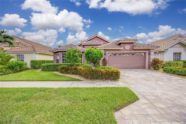 mediterranean / spanish house with a tiled roof, a front yard, stucco siding, decorative driveway, and a garage