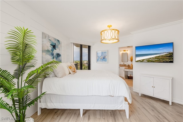 bedroom featuring crown molding, light hardwood / wood-style flooring, and ensuite bathroom