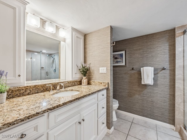 bathroom featuring tile patterned floors, vanity, toilet, and an enclosed shower