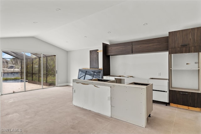 kitchen featuring dark brown cabinetry, light tile patterned floors, and vaulted ceiling