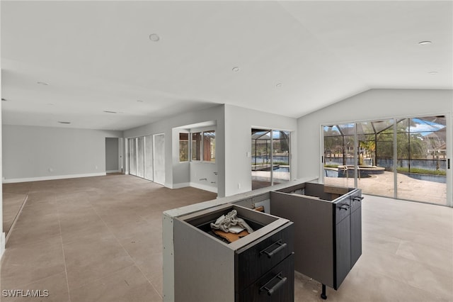 kitchen featuring light tile patterned flooring, lofted ceiling, and a center island