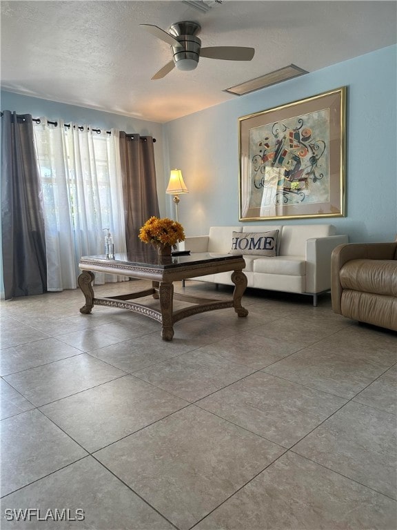 living area with a textured ceiling and ceiling fan