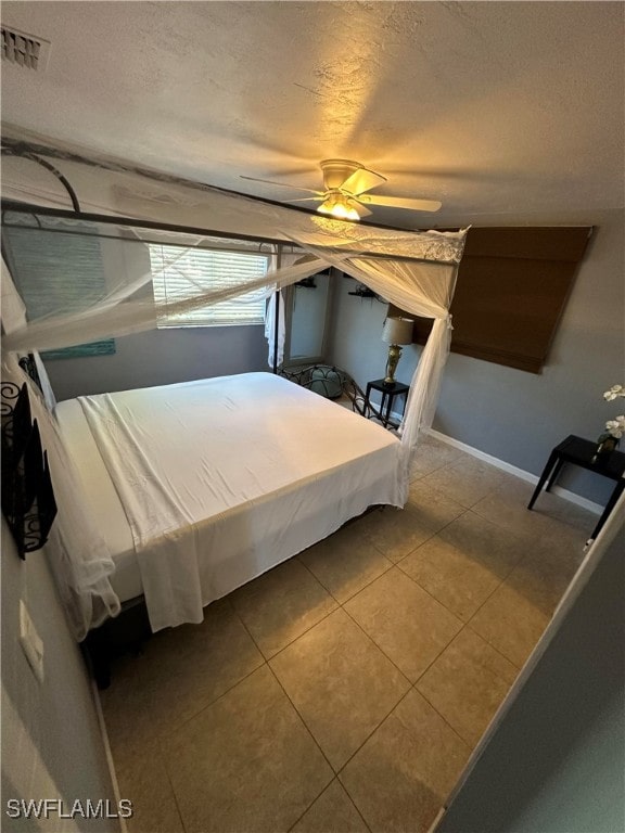 unfurnished bedroom featuring a textured ceiling, tile patterned flooring, and ceiling fan