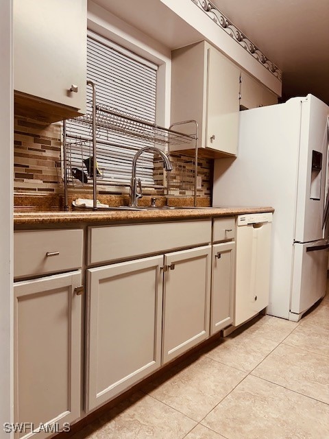 kitchen with white appliances, sink, light tile patterned floors, and backsplash