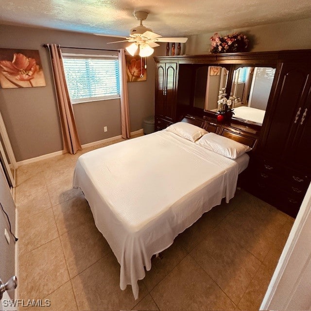 bedroom featuring light tile patterned flooring, a textured ceiling, and ceiling fan