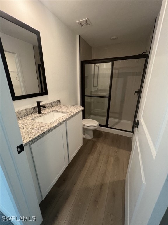 249 Blackstone Dr, Fort Myers, FL 33913 - bathroom with wood finished floors, a stall shower, toilet, and vanity