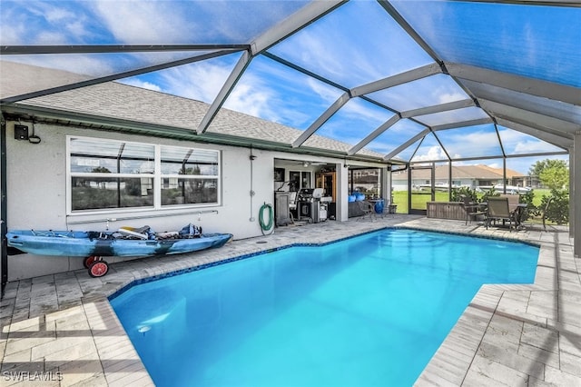 view of pool featuring glass enclosure and a patio area