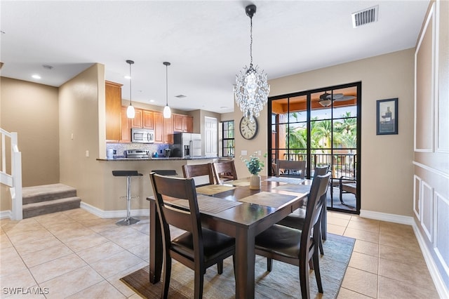 tiled dining area featuring a chandelier