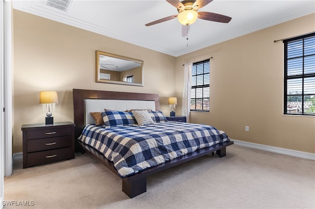 bedroom with ornamental molding, multiple windows, light colored carpet, and ceiling fan