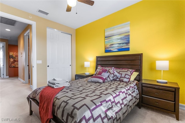 bedroom with ceiling fan, light carpet, and a closet