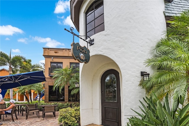 view of exterior entry with a patio area