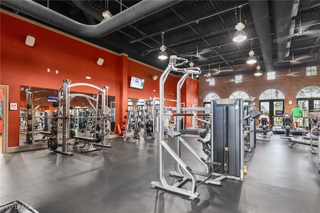 exercise room featuring a high ceiling and rail lighting